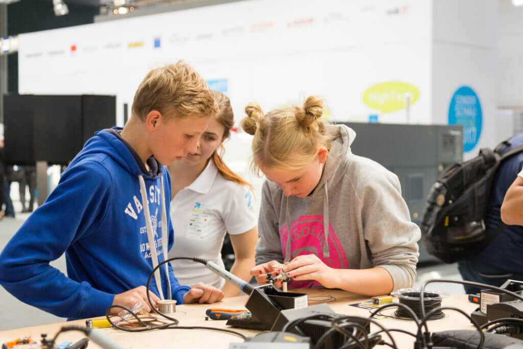 A highlight at the Youth Education and Development Foundation’s special booth for youth is a process chain from the drawing up to as-sembly of a Formula 1 model car. Young visitors concentrate on their work building this model.