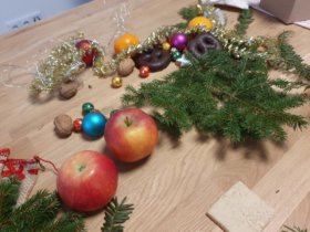 Ein Diorama entsteht: Zweige, Obst, Nüsse, eine Lichterkette und weihnachtliches Dekomaterial bilden die Kulisse für die Fotografien. (Dr. Stefan Schwaneck)