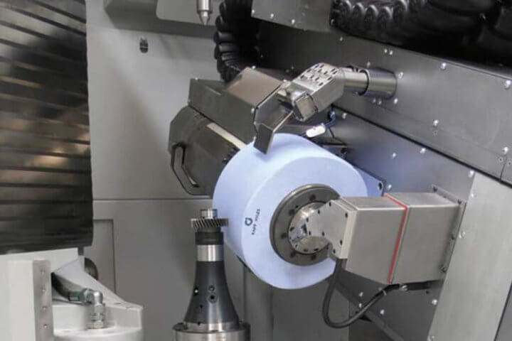 Workspace of a gear grinding machine. Very high rotational energy levels can arise in large grinding tools, such as those used for generation grinding. If a grinding wheel does burst, it can cause serious injury to the machine operator. Source: Kapp
