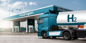 LKW mit Wasserstofftank-Anhänger auf einem Hintergrund von H2-Tankstelle. Quelle AdobeStock